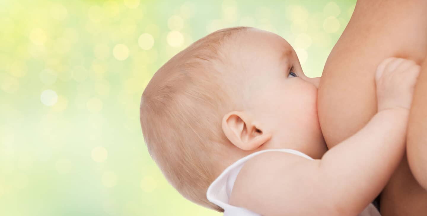 people, babyhood, nursing, lactation and children concept - close up of breastfeeding baby