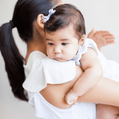 mom holding baby over her shoulder with a burp cloth