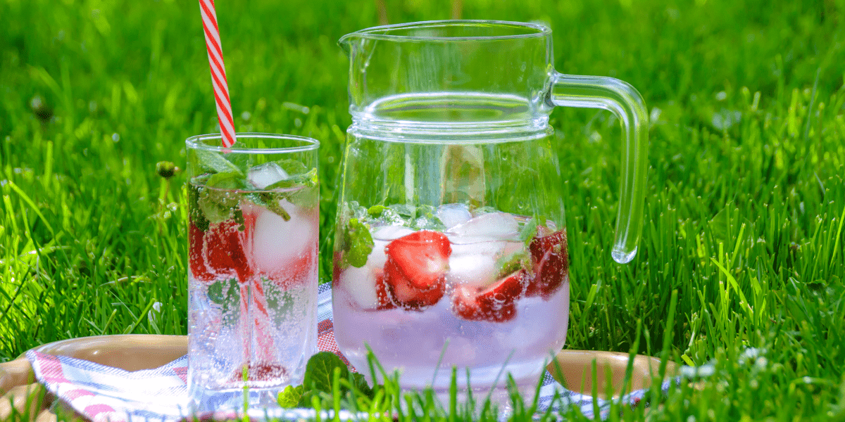 iced water in a jug and glass with strawberries