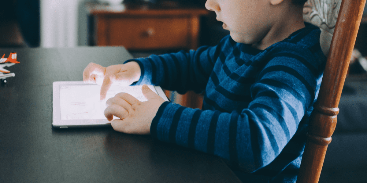 child with tablet on table