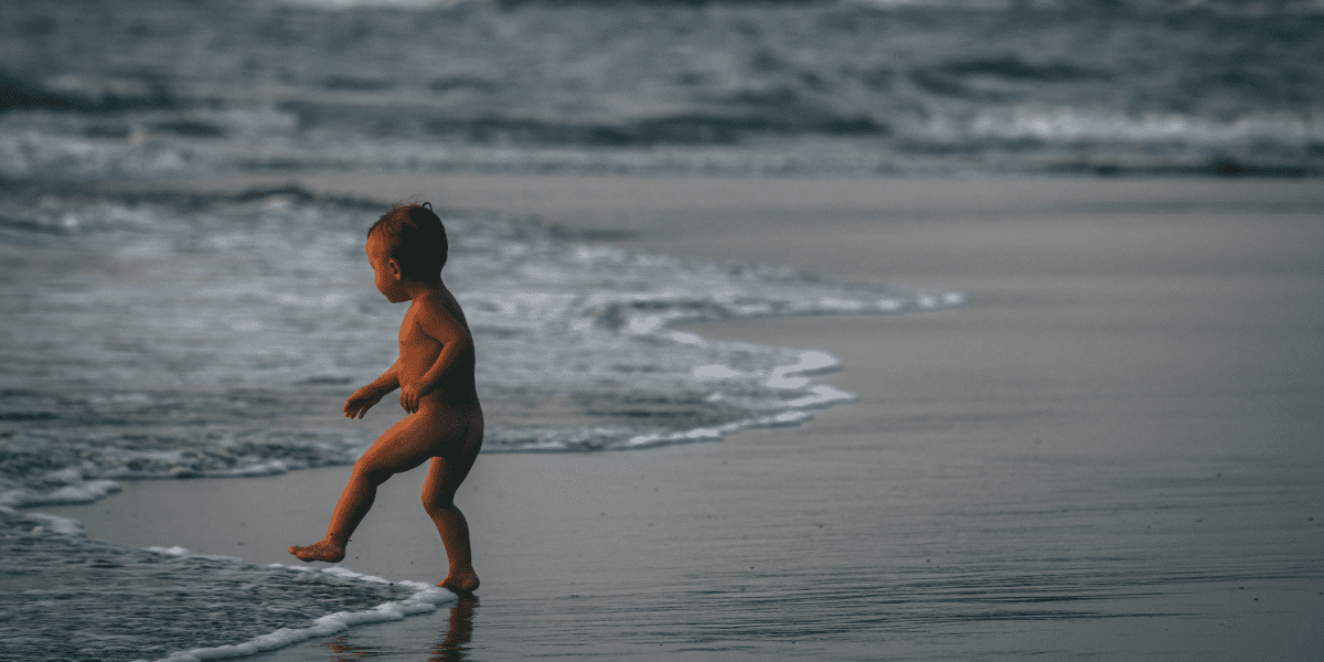 boy standing at the edge of the sea