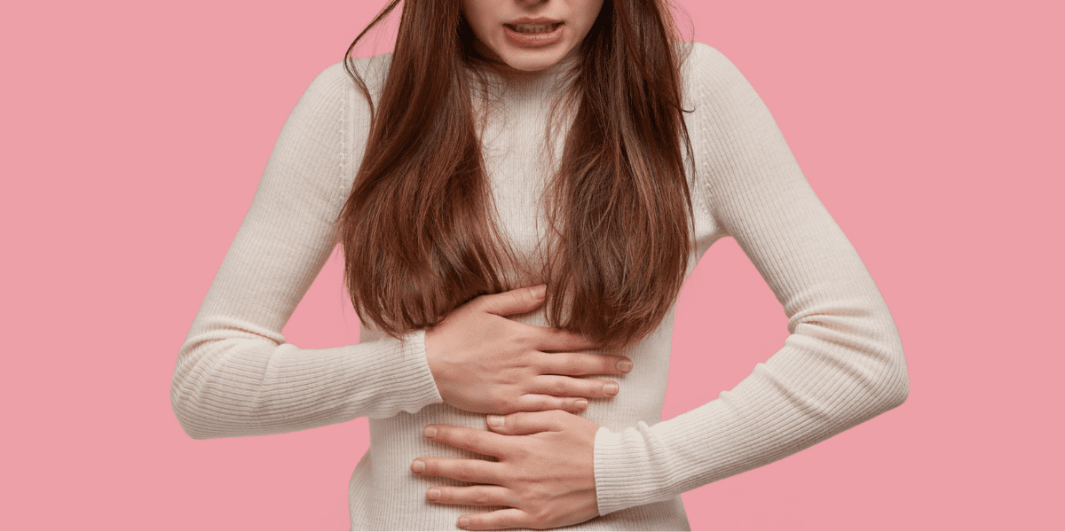 woman holding her stomach in pain