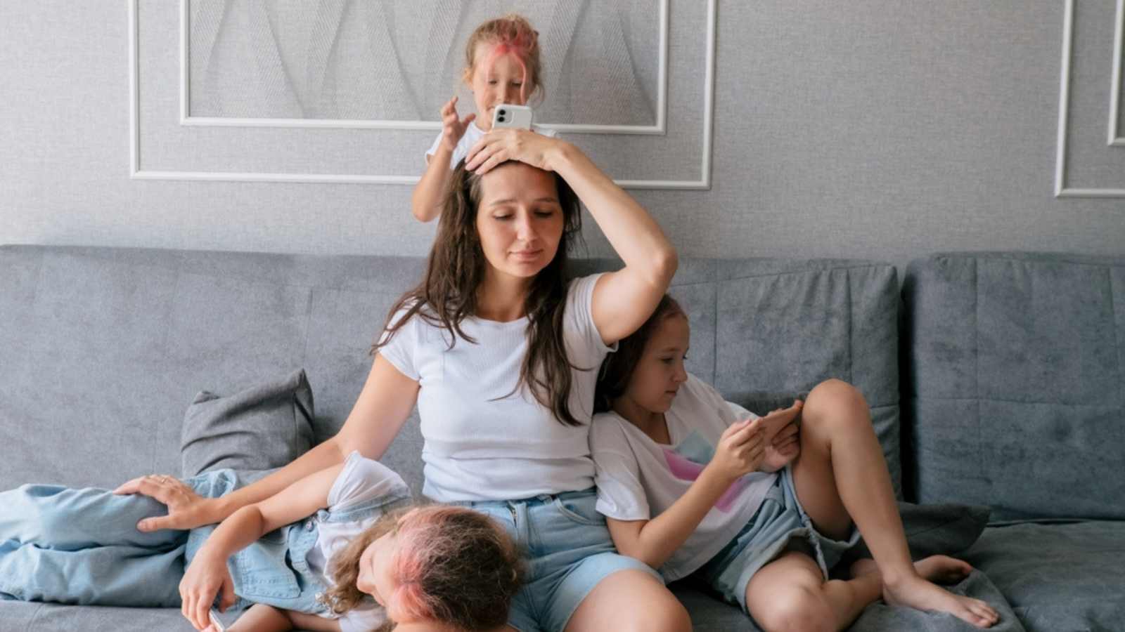 Tired mother on couch with children
